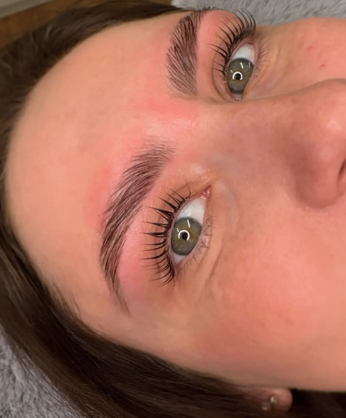 Close view of a client’s lifted lashes and laminated brow after a Korean lash lift