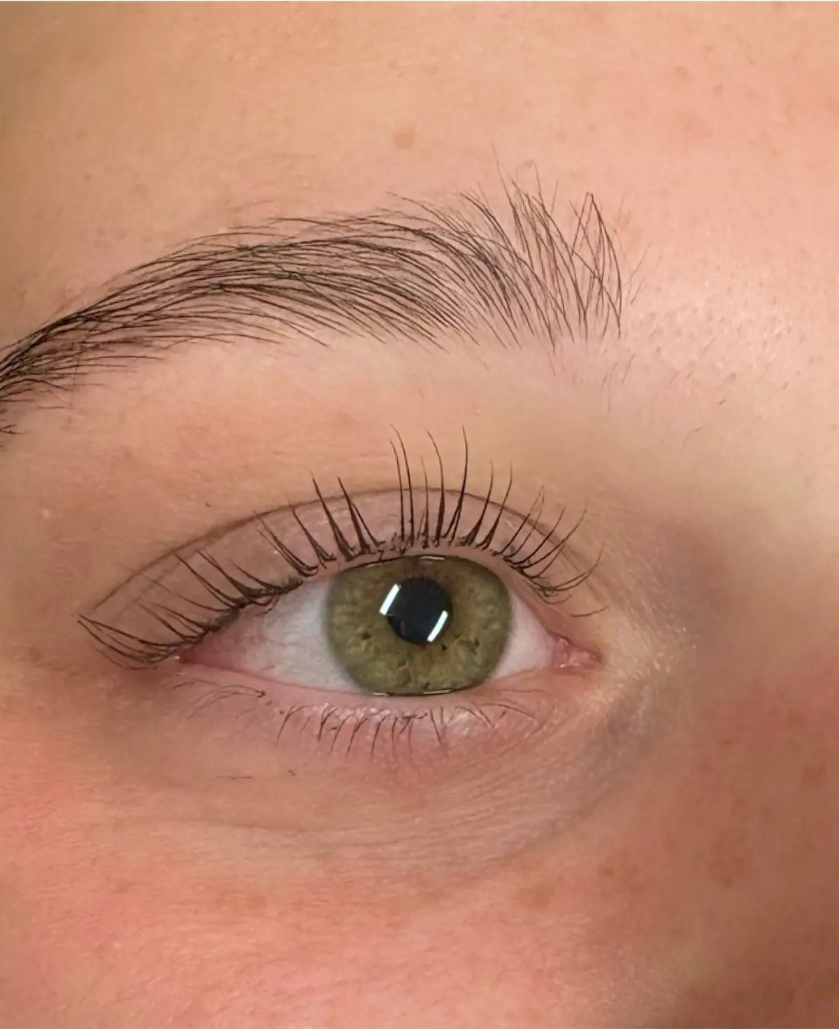 Close view of a client’s eye with lifted, curled lashes after a lash lift